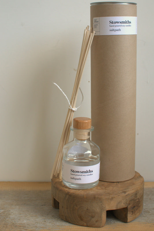 Stowsmiths diffuser set with bottle, sticks, and cardboard tube on a wooden stand.